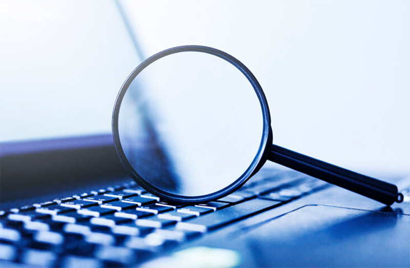 stock image of magnifying glass on a laptop keyboard